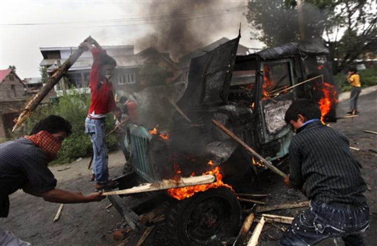 Kashmiri protesters hit a burning government vehicle after they set it on fire in Srinagar, India. Nearly every one of the valley's 6 million people has been touched by violence.